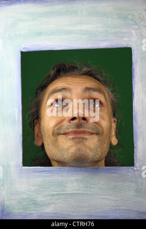 happy man smiling behind a picture frame Stock Photo