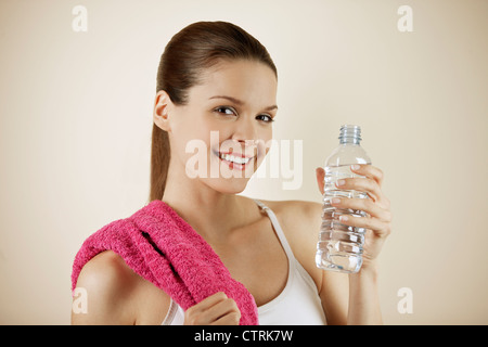 A young woman holding a bottle of water, close-up Stock Photo