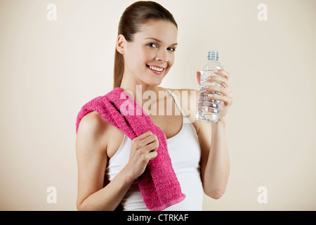 A young woman wearing fitness clothing, holding a bottle of water Stock Photo