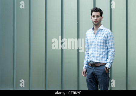 Young man wearing a shirt standing in front of a wall Stock Photo