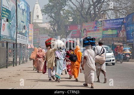Indian pilgrims carrying luggage on their heads while walking to the Holi festival in Vrindavan, Uttar Pradesh, India Stock Photo