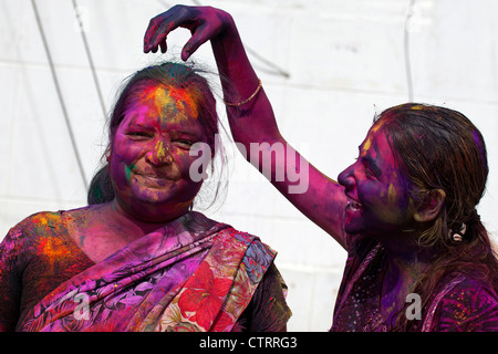 Women covered in colourful dye celebrating the Holi festival, Festival of Colours in Mathura, Uttar Pradesh, India Stock Photo