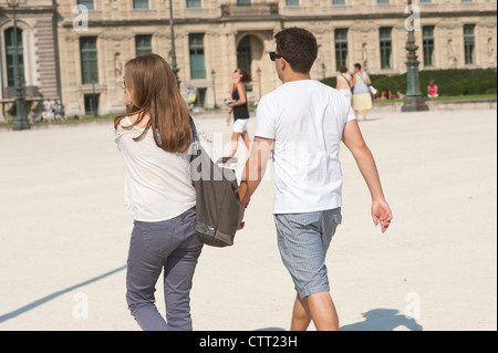 Paris, France - August 2012  - Young couple   hand in hand walking in the Louvre Museum area. Stock Photo