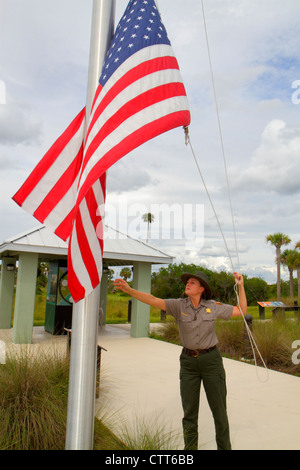 Naples Florida,Everglades,Big Cypress National Preserve,Big Cypress Swamp Welcome Center,park ranger,flagpole,flag,lowering,visitors travel traveling Stock Photo