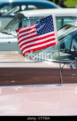 American flag flying from an old classic american car. English American car show Stock Photo