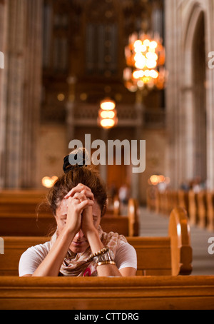 A woman praying in Uppsala's cathedral. Uppsala, Sweden. Stock Photo