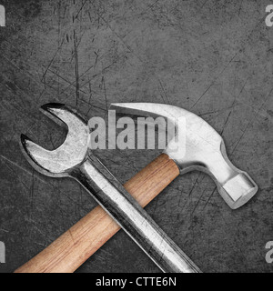 spanner and hammer on Scratched metal background. Stock Photo
