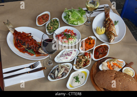 Deep fried fish and a mezze of Mediterranean Salads Stock Photo