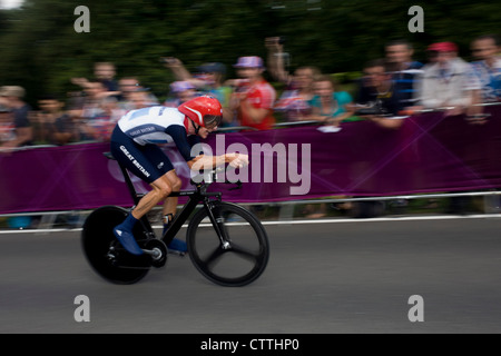 Team GB cyclist Bradley Wiggins races past fans lining the route through Bushy Park in south west London, during the London 2012 Olympic 44km men's cycling time trial, eventually won Wiggins, 42 seconds ahead of German Tony Martin. Stock Photo