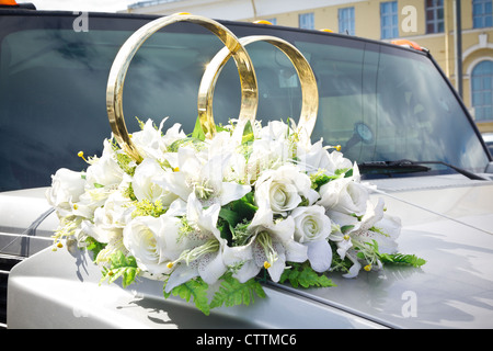 White wedding limousine decorated with flowers and gold rings Stock Photo