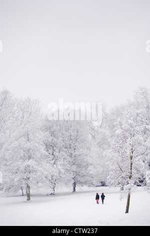 Two people enjoying a walk in the fresh snow in Waterlow Park, Highgate, North London. Stock Photo