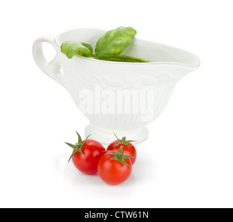 Three cherry tomatoes and pesto sauce. Isolated on white background Stock Photo