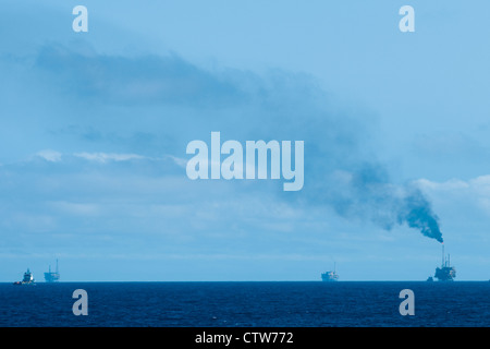 oil rigs in offshore area.... smoke going to atmosphere. Stock Photo