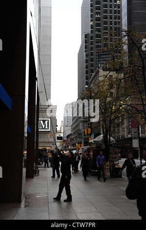 Urban alley sidewalk portrait, to 7th Avenue, man using telescopic squeegee, facade Chase Bank, West 52nd Street, New York Stock Photo