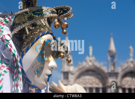 Souvenir Carnival mask on stall in St Mark's Square with St Mark's Basilica out of focus in background Venice Veneto Italy Stock Photo