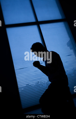 Man kneeling and praying. Stock Photo