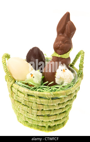 A straw basket containing chocolate Easter eggs and a chocolate Easter bunny - studio shot with a white background Stock Photo