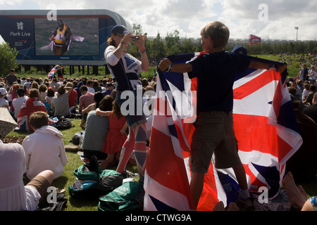The Team GB canoe slalom pair David Florence and Richard Hounslow celebrate after their C2 final race watched by celebrating fans in the Olympic Park during the London 2012 Olympics. This land was transformed to become a 2.5 Sq Km sporting complex, once industrial businesses and now the venue of eight venues including the main arena, Aquatics Centre and Velodrome plus the athletes' Olympic Village. After the Olympics, the park is to be known as Queen Elizabeth Olympic Park. Stock Photo