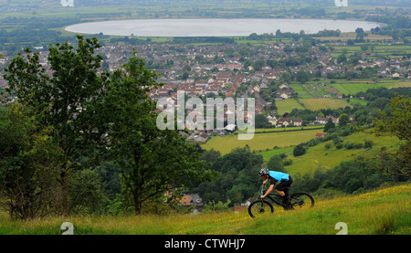 A mountain biker rides along the edge of the Cheddar Gorge above the village of Cheddar in Somerset on the edge of the Mendips Stock Photo