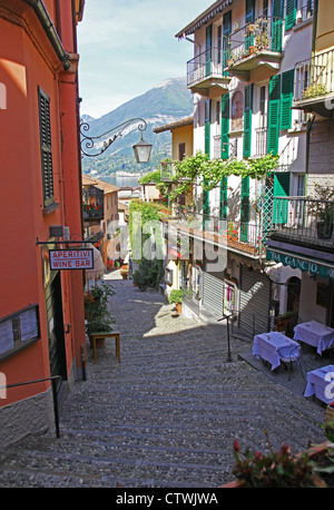 The narrow picturesque street of Salita Serbelloni Bellagio Lake Como Italy with an Italian restaurant and outdoor tables Stock Photo