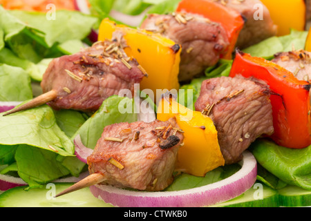 Pork kebabs or Souvlaki served on a bed of salad - studio shot Stock Photo