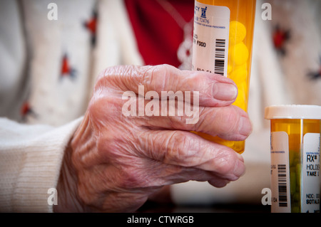 Elderly woman holding a pill bottle Stock Photo