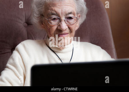 Elderly woman working on a laptop computer Stock Photo
