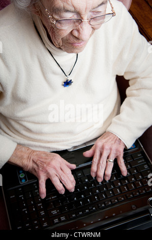Elderly woman working on a laptop computer Stock Photo