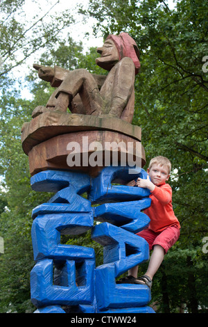 young boy climbing the statue in front of the open-air museum in Lehde near Luebbenau, Spreewald, Brandenburg, Germany Stock Photo
