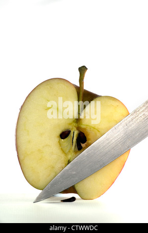Close up of apple cut in half  with knife isolated on a white background Stock Photo