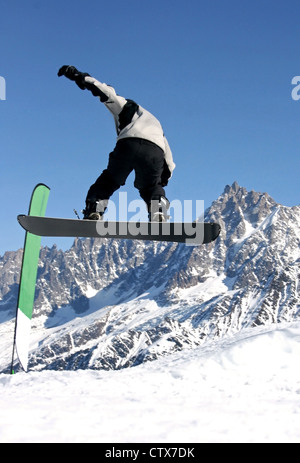 A snowboarder jumping freestyle in the mountains Stock Photo