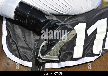 Detail of the saddle cloth, stirrup, reins and boots on a racehorse and jockey Stock Photo