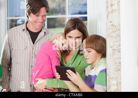 Boy using a digital tablet with his parents beside him Stock Photo