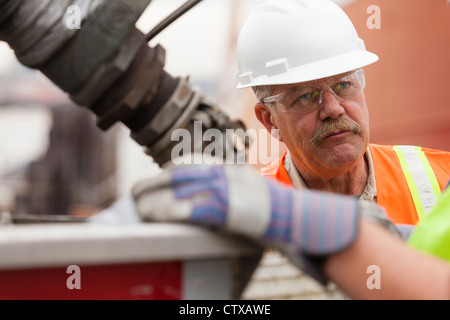 Environmental engineers with valves and fittings on back of tanker truck Stock Photo