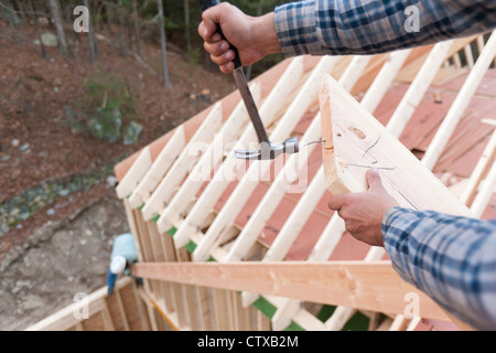 Carpenter removing nail from rafter end Stock Photo