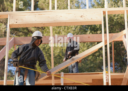 Carpenter measuring width of picture window frame Stock Photo