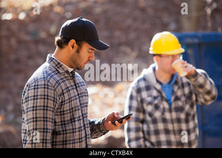 Carpenter using a mobile phone at construction site Stock Photo