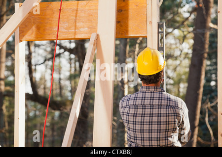 Carpenter using a level on framing Stock Photo