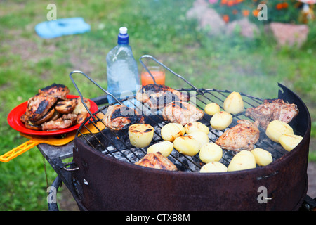 Roasted meat and potatoes on the brazier Stock Photo