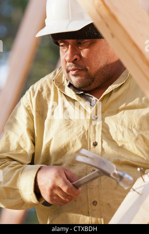 Carpenter removing nails from stud Stock Photo