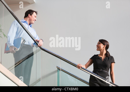 Business couple talking on stairs of office building Stock Photo