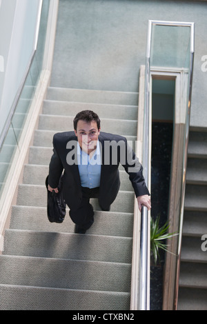 Businessman with briefcase on stairs of office building Stock Photo