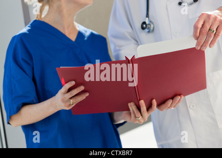 Doctor looking at files held by a nurse Stock Photo
