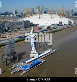 Aerial view of North Greenwich Peninsula & Pier Thames Clipper river bus beside O2 arena millenium dome 2000 & Canary Wharf skyline beyond London UK Stock Photo