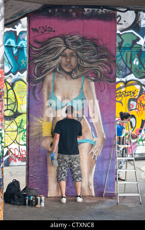 Portrait of aerosol graffiti artist at work , London, England, UK. Stock Photo