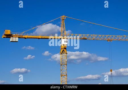 Construction crane against a blue sky with cloud background. Stock Photo
