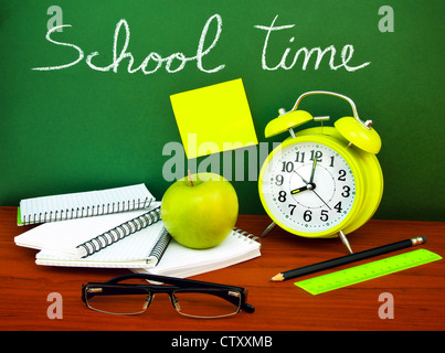 Back to school concept, green chalkboard with handwriting and set of colorful student accessories Stock Photo