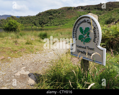 National Trust sign for Llyndy Isaf farm by path around Llyn Dinas lake in Snowdonia. Nantgwynant, North Wales, UK, Britain Stock Photo