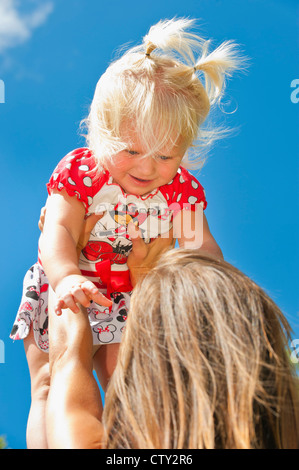 Parenting mother raising her 2 years old girl up Stock Photo