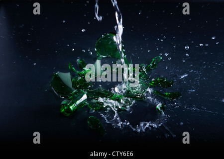 Pouring water onto the broken glass bottle Stock Photo